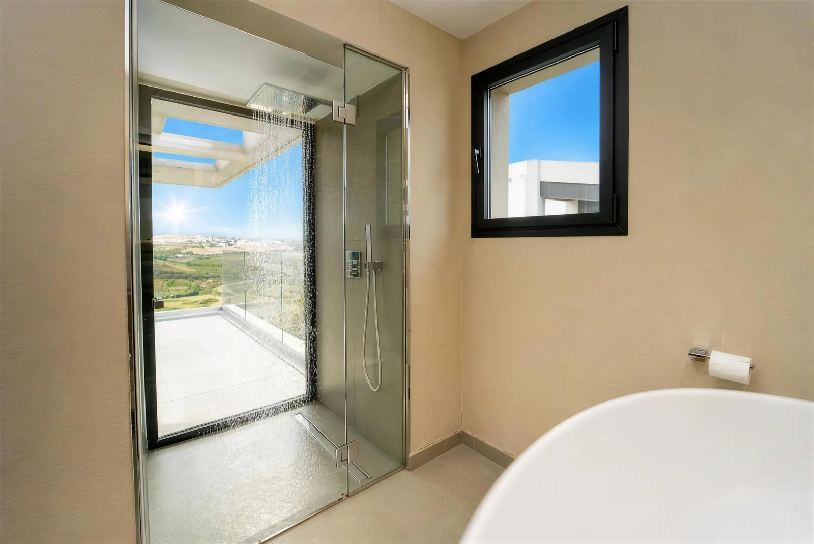 Main bathroom with rain shower by the window and freestanding bathtub