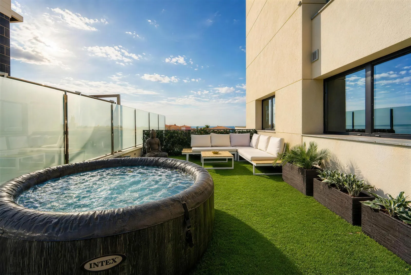 Terrasse mit Whirlpool, weißen Sofas und Pflanzkübeln